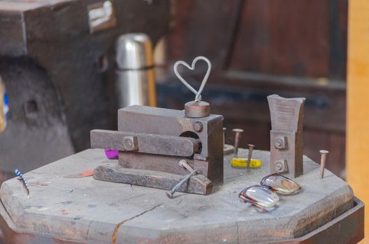 An old abandoned locksmith shop. Pictured anvil and different tools and objects.