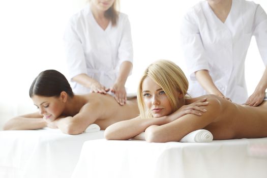 Two beautiful women getting massage in spa