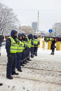 RIGA, LATVIA, MARCH 16, 2010: Local police guard cordon behind crowd control barriers at the Freedom Monument at the commemoration of the Latvian Waffen SS unit.