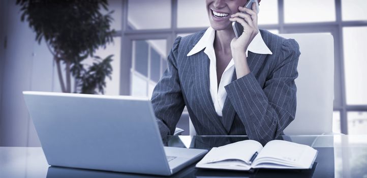 businesswoman on call and using her laptop in an office