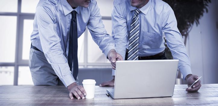 Businessmen using laptop in office