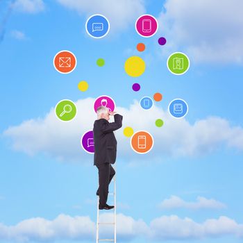 Mature businessman standing on ladder against sky 