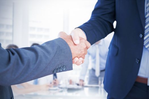 Businessmen shaking hands against business people in office at presentation
