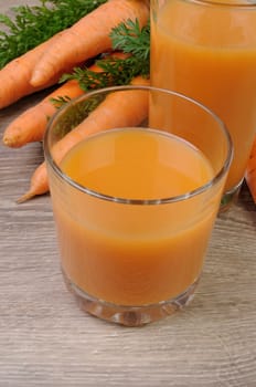 glass of  carrot juice on the table with carrots  