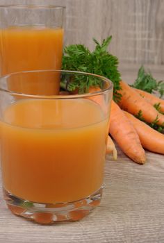 glass of  carrot juice on the table with carrots  