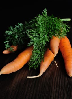 bundle of raw carrots on the table dark background