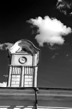 tower with ancient clock on old manor roof and dark sky with cloud,b&w picture