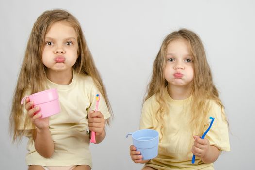 Two girls of four and six years of brushing their teeth toothbrushes