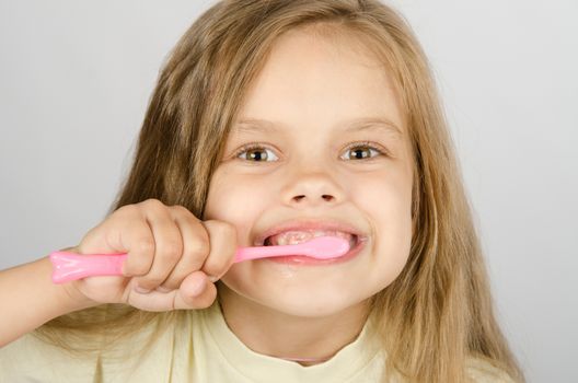A girl of six years of brushing his teeth with a toothbrush