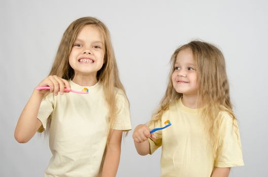 Two girls of four and six years of brushing their teeth toothbrushes