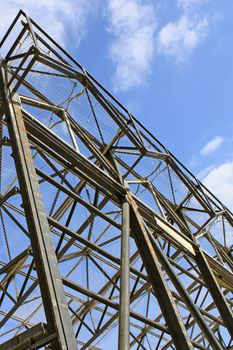 a metal frame with safety net against blue sky with clouds