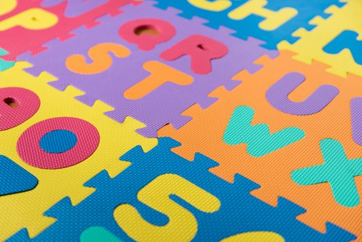 A section of a colorful foam ABC puzzle/floor mat.