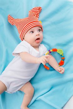 baby in a striped hat on a blue blanket