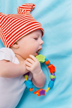 baby in a striped hat on a blue blanket