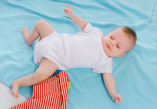 dissatisfied baby lying on a blue blanket
