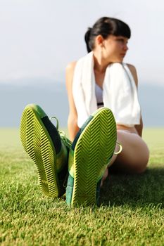 green sole of shoes on grass, tired sportswoman