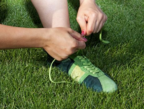woman ties laces on the sports shoes
