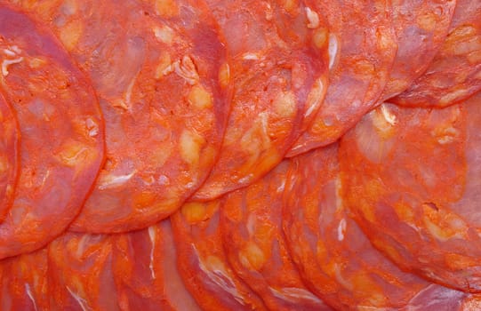 Chorizo slices, a Spanish spicy deli meat, as an abstract background texture