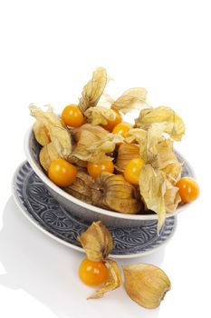 Physalis, groundcherries in bowl isolated on white background. Tropical healthy fruit eating.