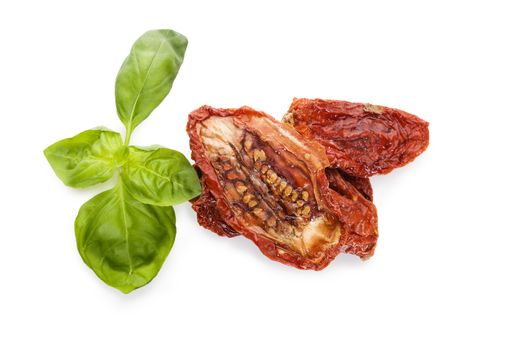 Dried tomatoes with fresh basil herb isolated on white background, top view. Culinary mediterranean eating. 