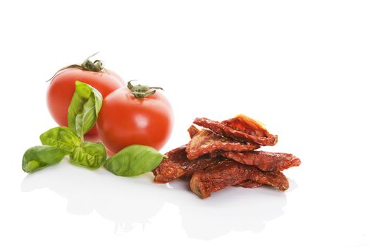 Sundried tomatos, fresh tomatoes and fresh basil herbs isolated on white background. Culinary italian eating.