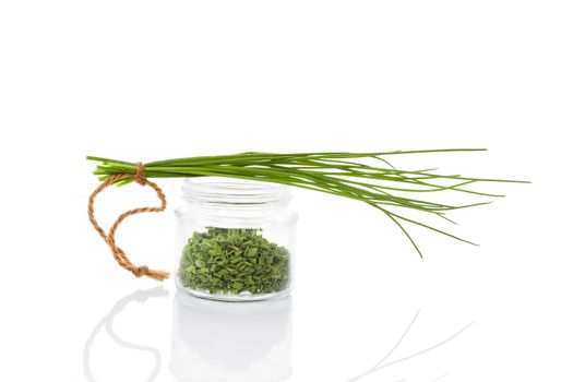 Fresh chives and dry chive spice in glass jar isolated on white background. Culinary healthy aromatic herbs. Fines herbes, culinary arts.