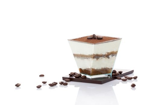 Tiramisu dessert on chocolate bar with coffee beans isolated on white background. Italian sweet dessert concept.