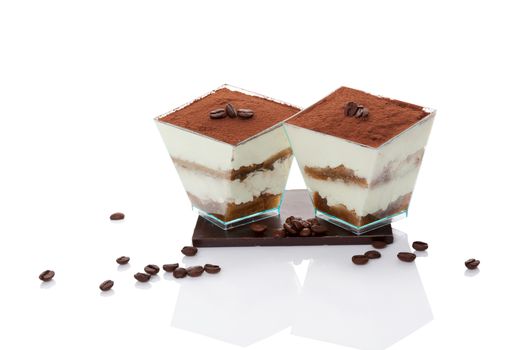 Tiramisu dessert on chocolate bar with coffee beans isolated on white background. Italian sweet dessert concept.