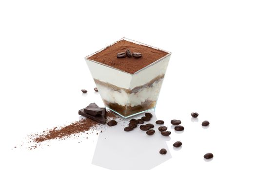 Tiramisu dessert with coffee beans, chocolate bar and cocoa powder isolated on white background. Traditional tiramisu dessert, modern minimal style. 