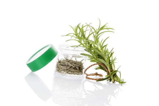 Fresh rosemary herbs and dry rosemary spice in glass jar isolated on white background. Culinary healthy aromatic herbs. Culinary arts.