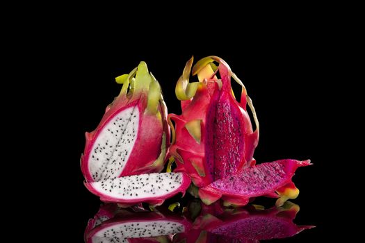 Red and white dragon fruits isolated on black background. Pitaya, tropical fruits, minimal luxurious style.