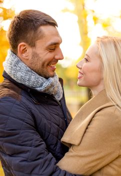 love, relationship, family and people concept - smiling couple hugging in autumn park