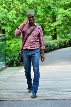 Casual man walking on street while talking on mobile