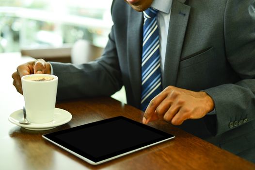 Businessman operating his digital tablet at cafe