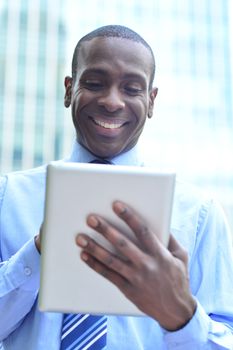 Smiling male executive working in his digital tablet