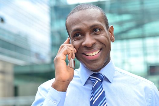 Happy corporate male speaking on his cell phone