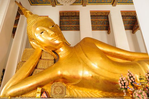 Reclining Buddha gold statue face. Wat Ratchaorotsaram, Bangkok, Thailand.