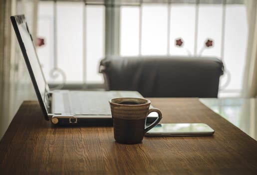 Business work place with cup of coffee smartphone and laptop.