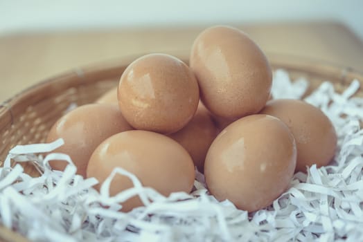 Eggs in a wicker basket on a wooden table