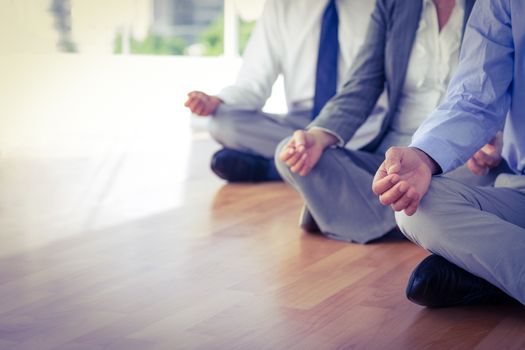 Close up view of business people doing yoga in office 