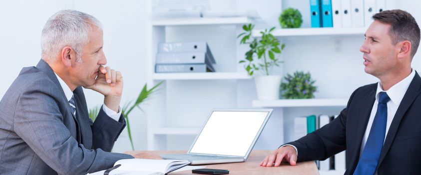 Two businessmen speaking and working at the office 