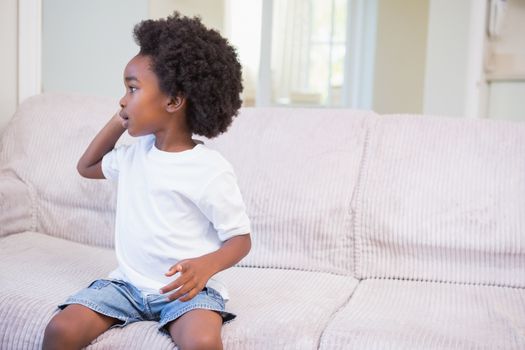 Little boy using a twechnology and phoning at home in bedroom 