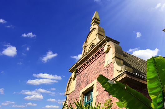 Ancient house facade gable of a villa in front of blue sky.