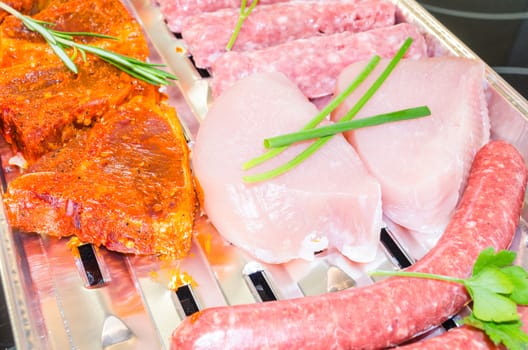 Close up various meats seasoned ready to grill.