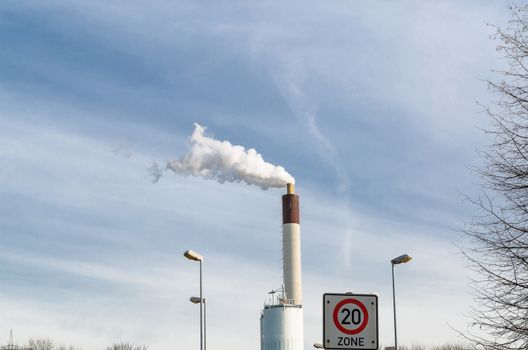 View of a power plant. Smoke comes from the chimney.