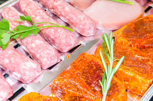 Close up various meats seasoned ready to grill.