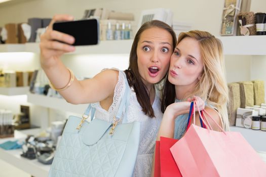 Happy women friends taking a selfie in a beauty salon
