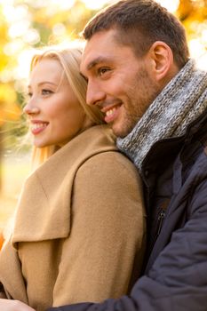 love, relationship, family and people concept - smiling couple hugging in autumn park