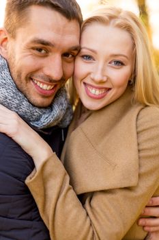 love, relationship, family and people concept - smiling couple hugging in autumn park