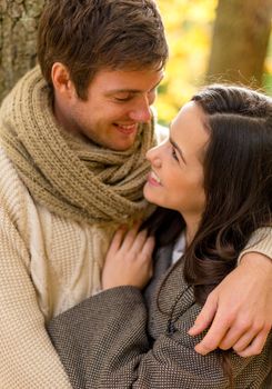 love, relationship, family and people concept - smiling couple hugging in autumn park